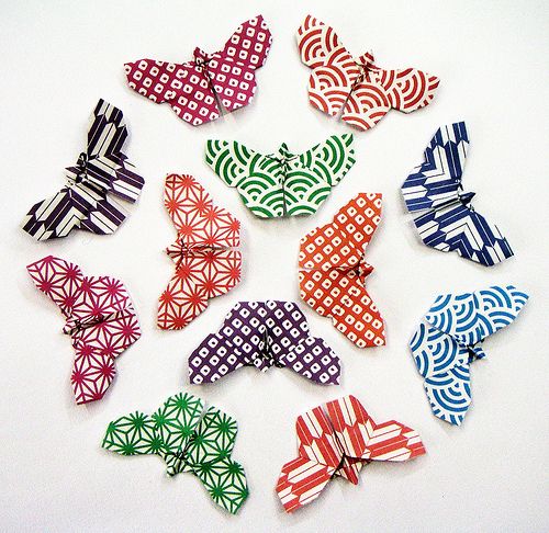 many different colored bows on a white surface with black and red designs in the middle