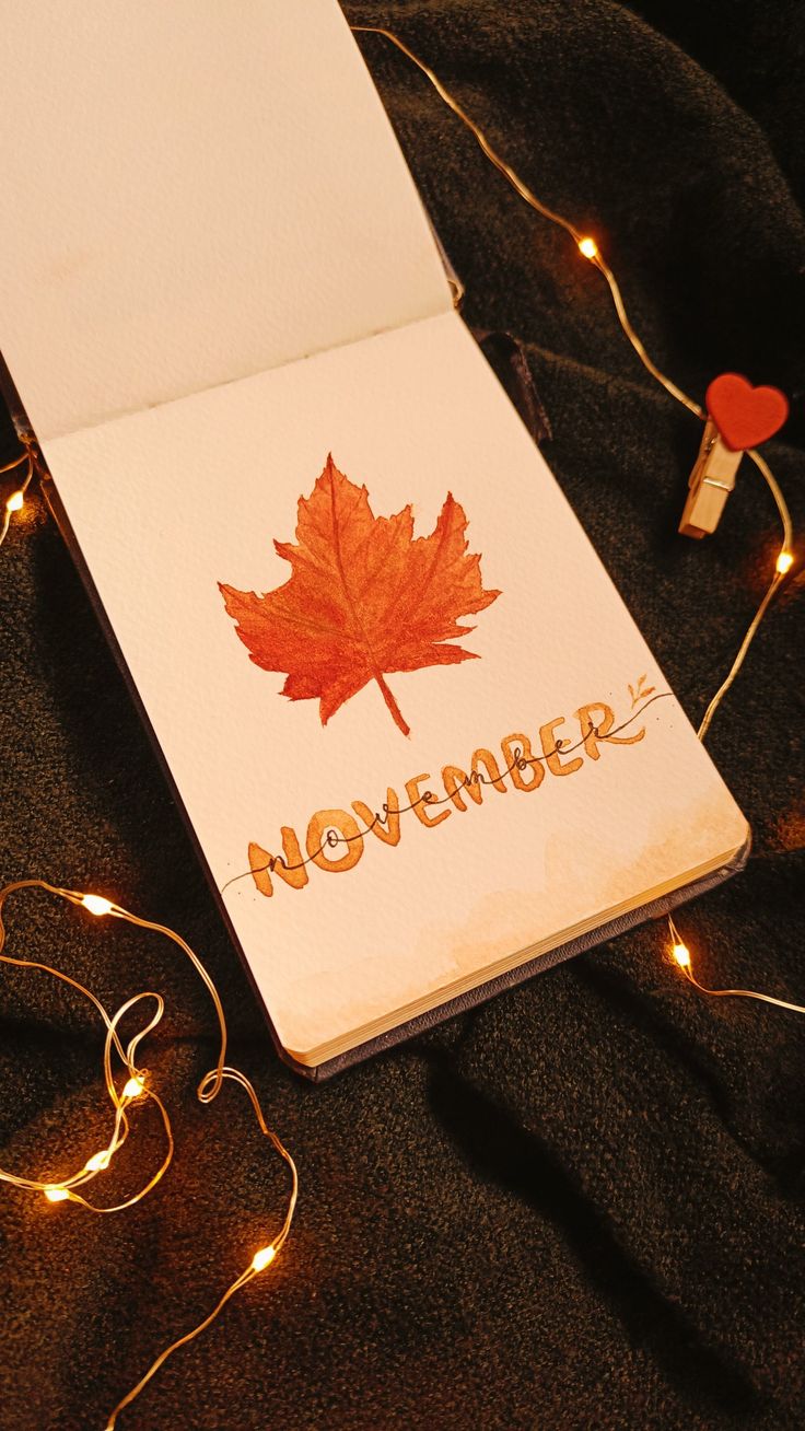 a notepad with a maple leaf on it and the word november written in gold