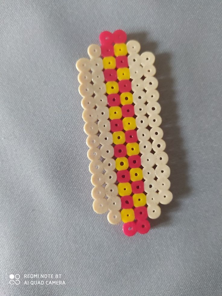 two pieces of white, yellow and red beaded brooch with holes in the middle