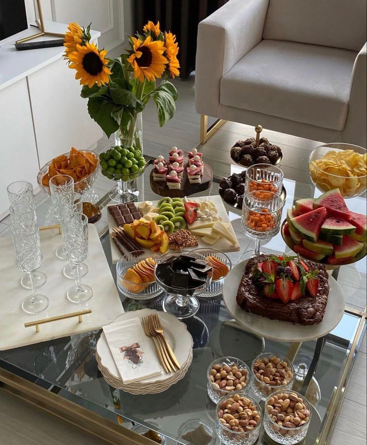 a glass table topped with lots of desserts and pastries on top of it