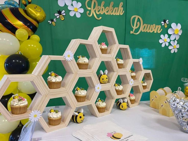 a table topped with cupcakes and honeycombs