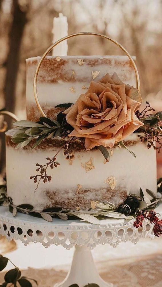 a wedding cake decorated with flowers and greenery