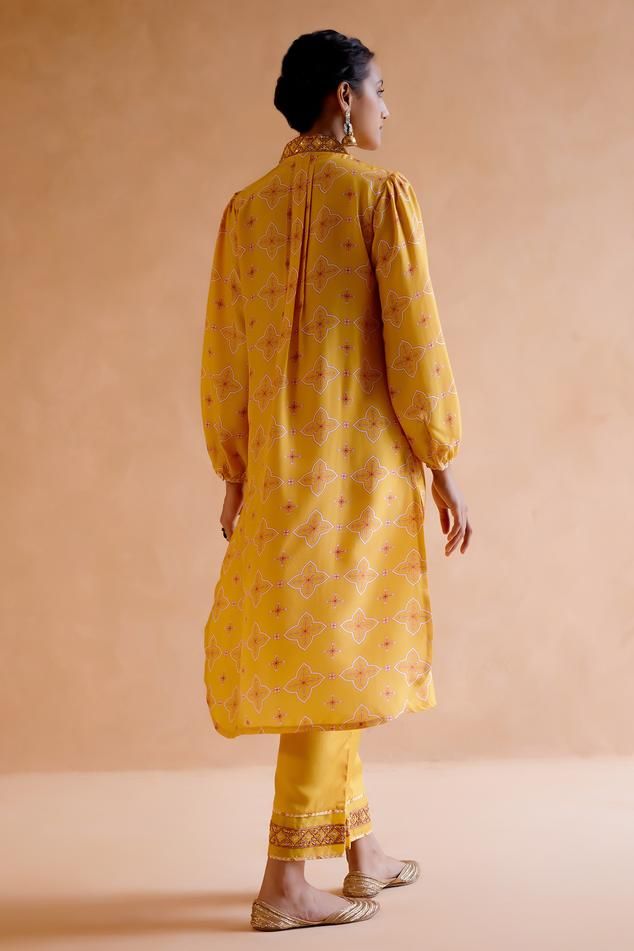 Yellow tunic with digitally printed tribal motifs featuring delicate hand embroidery in resham thread and zardosi on a V-shaped wrap around neckline. Paired with a tonal embroidered pant.
Components: 2
Pattern: Printed
Type Of Work: Digital print
Neckline: V Neck
Sleeve Type: Pleated
Fabric: Silk
Color: Yellow
Other Details: 
Kurta length: 44 inches
Model Height: 5ft 9inches, wearing size S
Occasion: Mehendi and Haldi - Aza Fashions Floral Print Tunic, Embroidered Pants, Yellow Silk, Pleated Fabric, Floral Tunic, Fabric Silk, Print Tunic, Pant Set, Set For Women