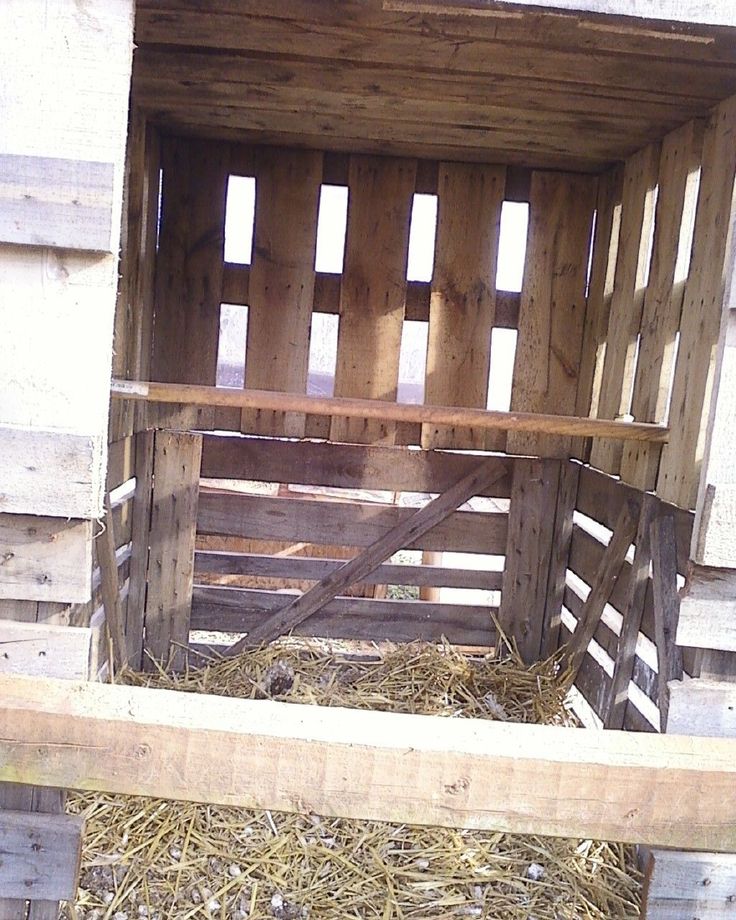 the inside of a wooden box with hay in it