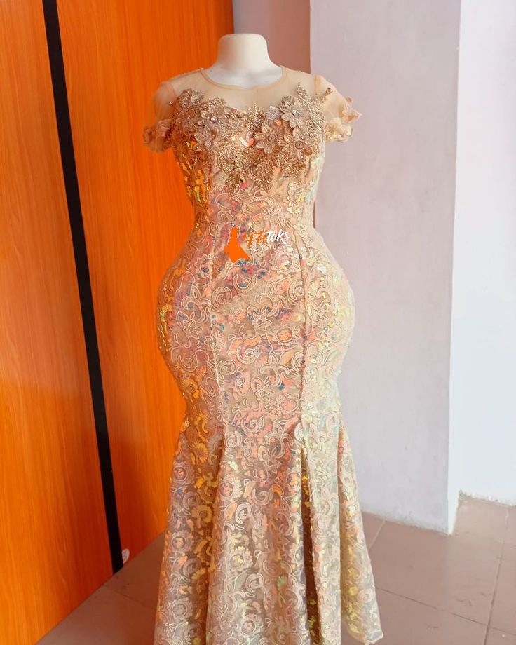 a dress on display in front of a wooden door with an orange wall behind it