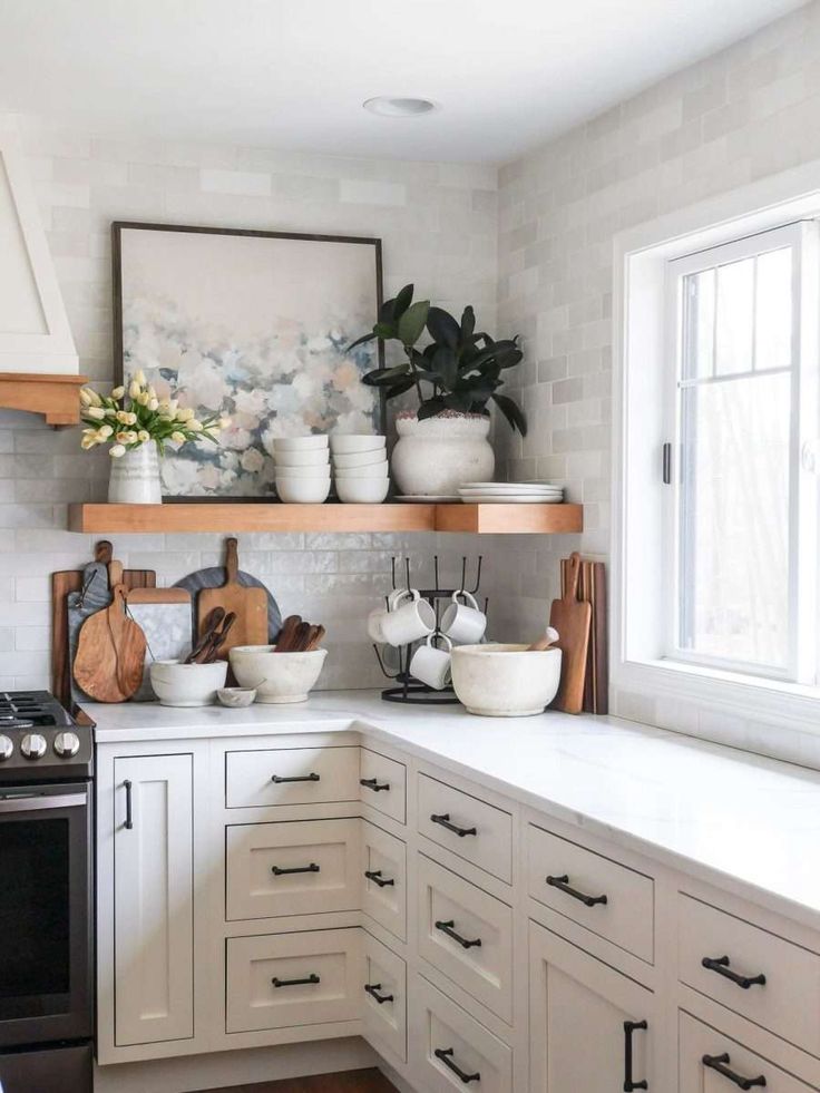 a kitchen with white cabinets and wooden shelves filled with pots, pans and bowls