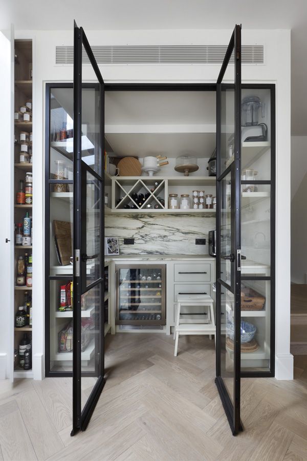 an open pantry with glass doors and shelves