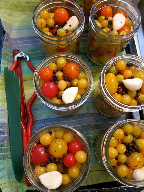 four glass jars filled with different types of food sitting on top of a table next to utensils