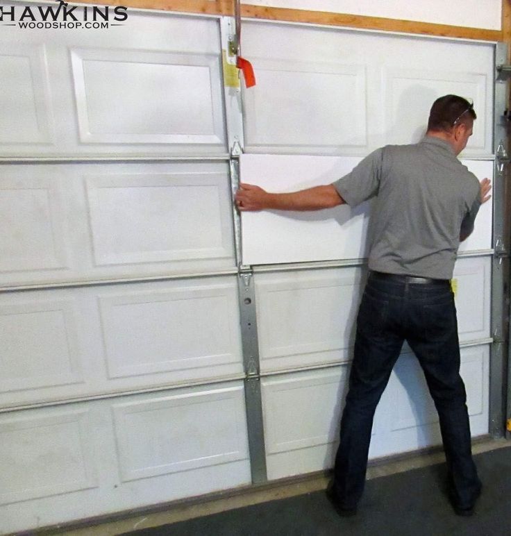 a man standing in front of a garage door with his hands on the handle bars