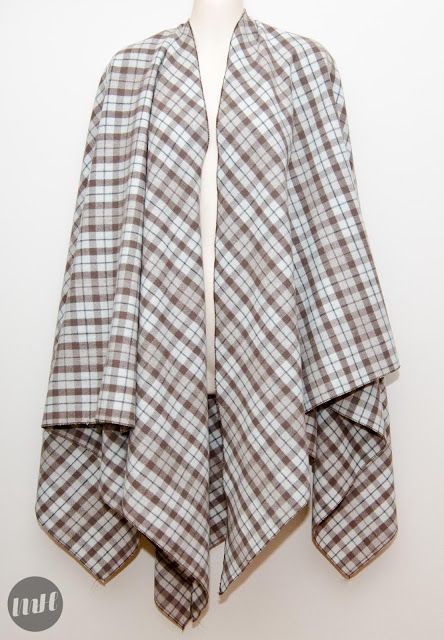 a white mannequin is standing next to a plaid jacket hanging on a wall