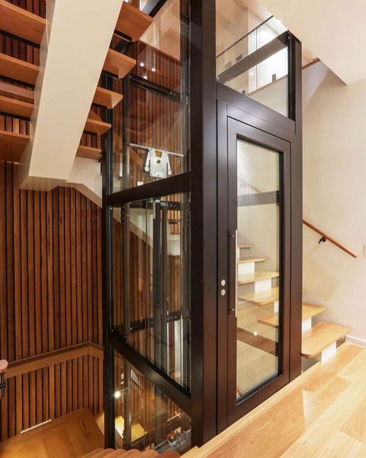 an open glass door in the middle of a wooden flooring area next to stairs