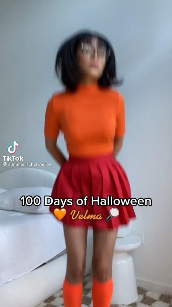 a woman in an orange shirt and red skirt standing next to a toilet with the words 100 days of halloween written on it