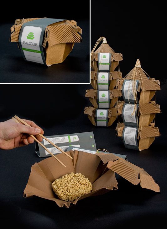 a hand holding chopsticks over some food in a paper bag with noodles on it