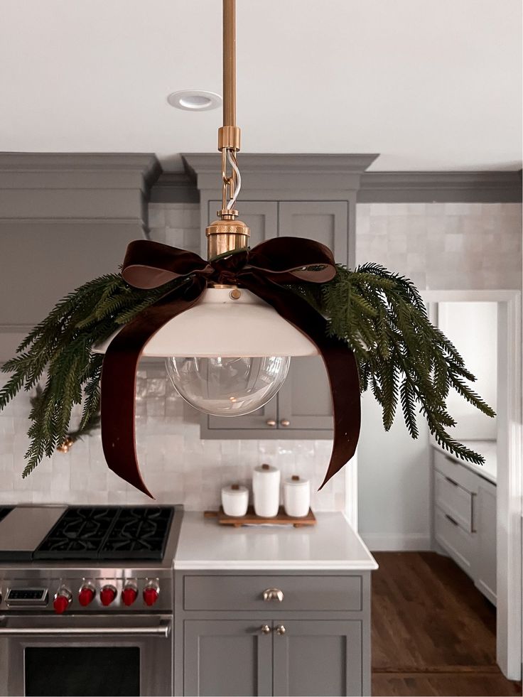 a christmas decoration hanging from the ceiling over a kitchen island with an oven and stove