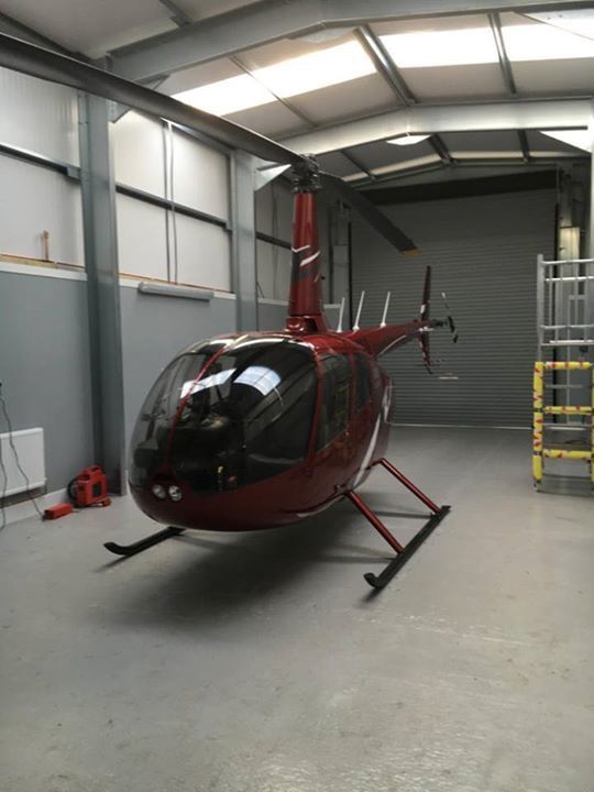 a red helicopter parked inside of a garage