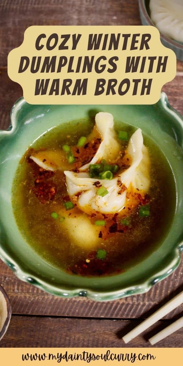 a green bowl filled with soup next to chopsticks and sauce on a wooden table