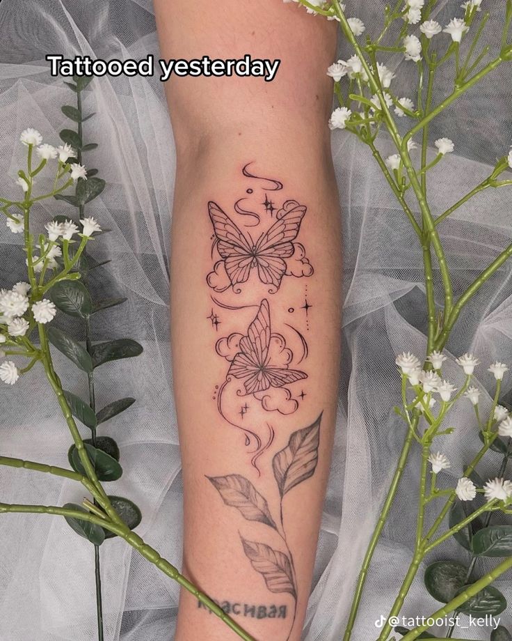 a woman's leg with flowers and butterflies on it