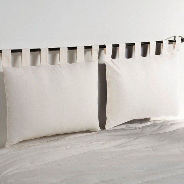 two white pillows sitting on top of a bed