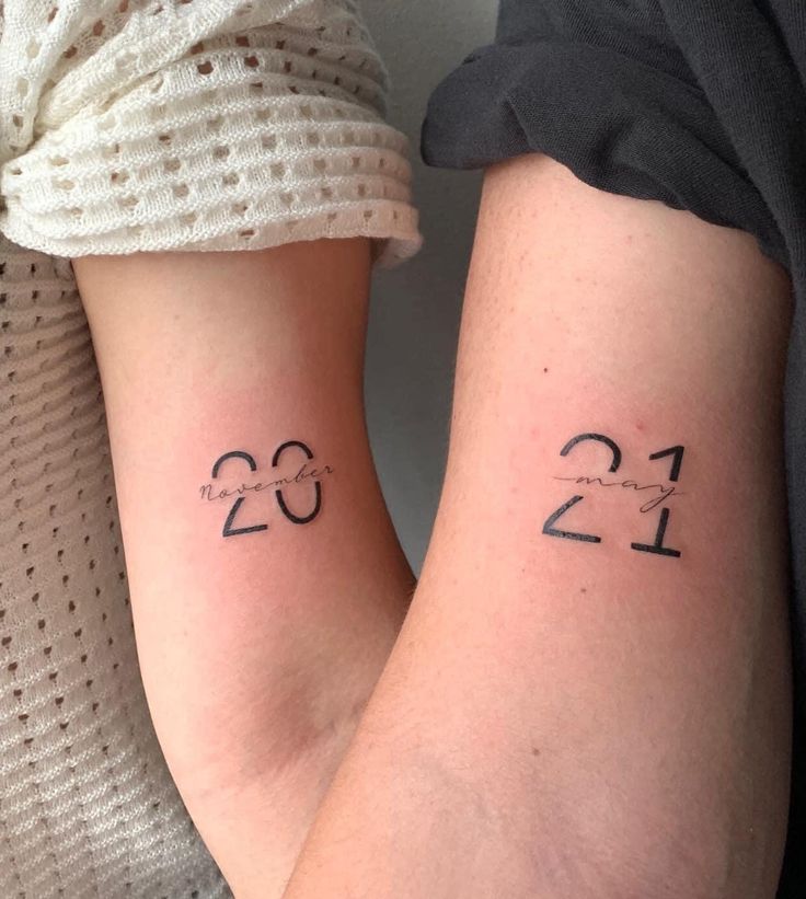 two people with matching tattoos on their arms, one has the number twenty and the other is