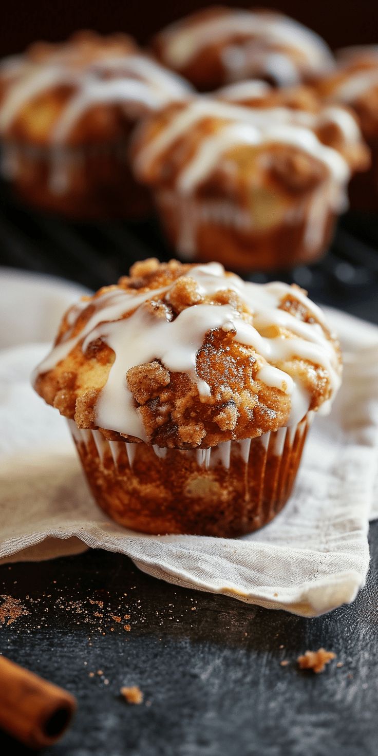 a muffin with white icing sitting on top of a napkin