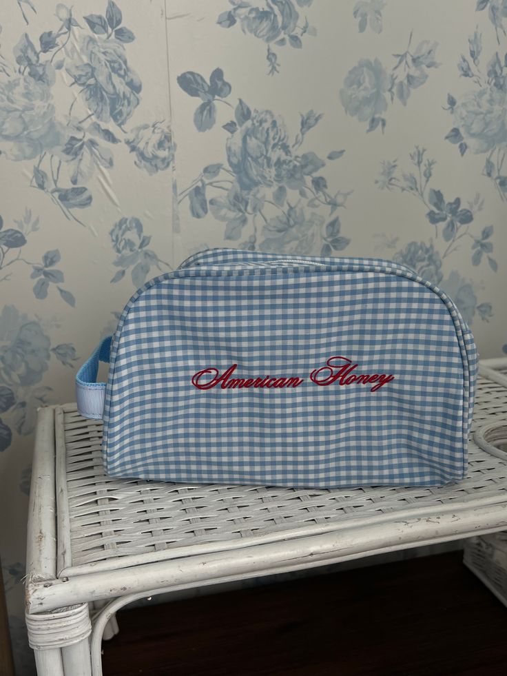 a blue and white gingham bag sitting on top of a wooden table next to a wall