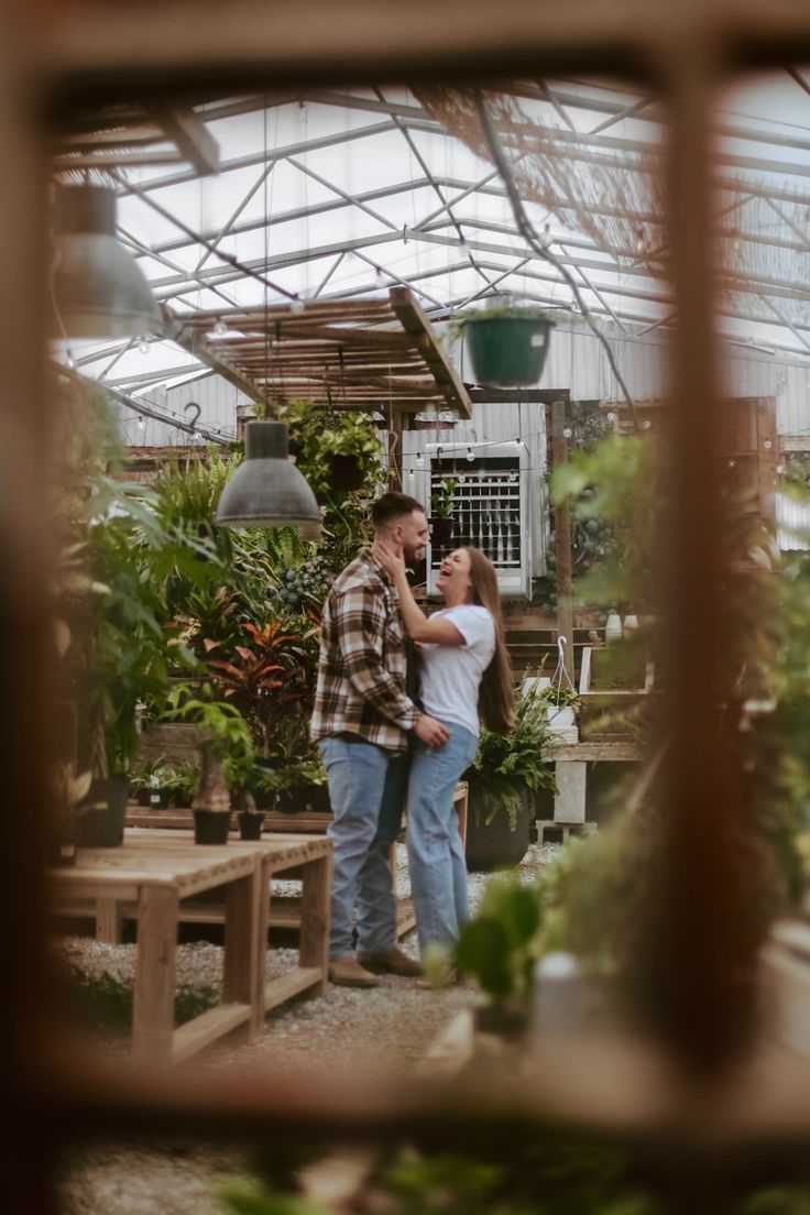 a man and woman standing in a greenhouse