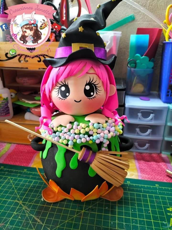 a little doll sitting on top of a black ball with a witch's hat