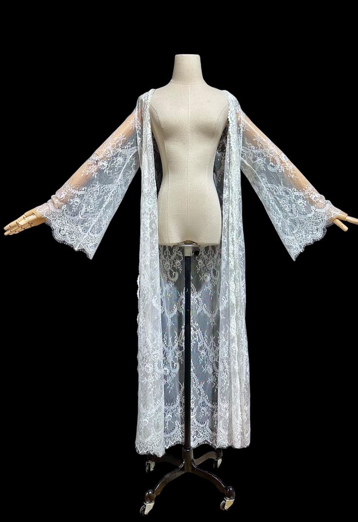 Ethereal sheer white lace dressing gown. Jonquil by Diane Samandi. Romantic and totally sheer dressing gown / dress. Gorgeous feather weight lace is 100% nylon. Just dreamy. Open front with tie sash.  Long bell sleeves. Excellent condition. I don't think it is the original belt. Measures: Variable sizing due to the wrap front. Tagged a size Medium. 16 across the shoulders 40 bust - open front  Cut straight 54 long  . White Lace With Long Sleeve Patchwork, White Lace With Long Sleeves And Patchwork, Sheer Fitted Party Robe, Lace Wedding Night Robe With Lace Sleeves, Long Lace Robe For Wedding Night, Fitted Lace Robe For Wedding Night, Fitted Sheer Lace Robe, Fitted Lace Robe With Lace Trim, Fitted Lace Robe With Sheer Details