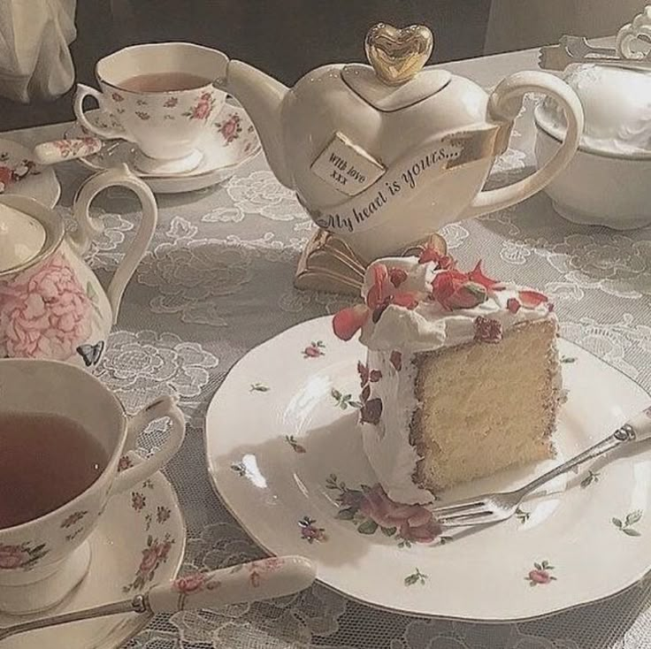 a piece of cake sitting on top of a plate next to cups and saucers