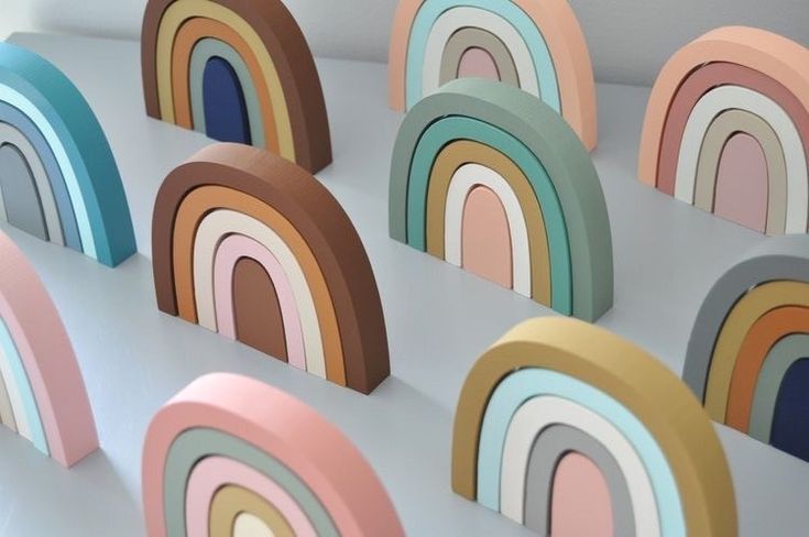 several wooden rainbows sitting on top of a white table next to eachother