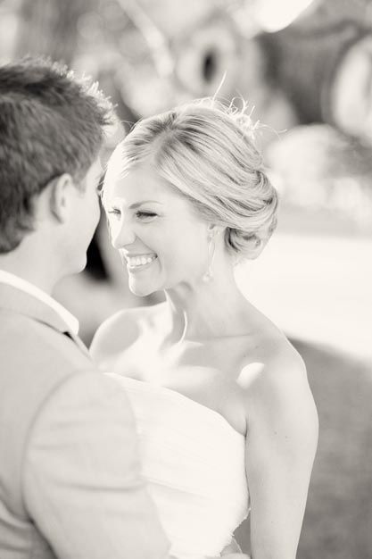 a bride and groom smile at each other