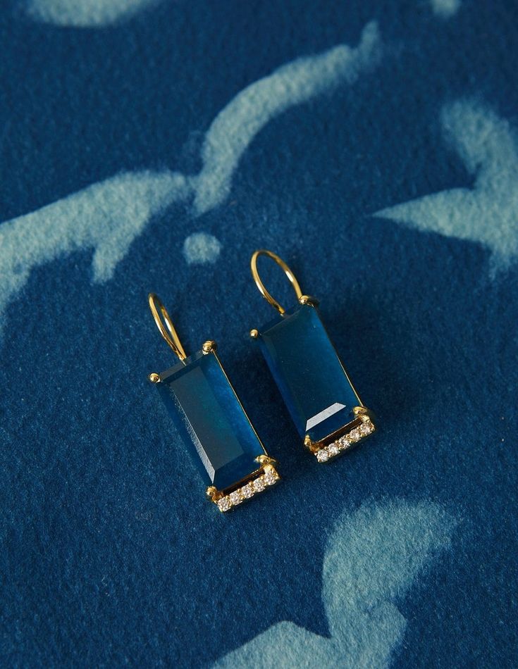 BEHIND THE DESIGN This classic light-weight earrings design showcases a stunning rectangular cut of a Blue Black Jade gemstone with a prong setting and a minimalist row of Cubic Zirconia. Designed to wear from day to night! DETAILS Metals: 18ct Gold Plated: a thick layer of 18ct Gold over brass. Nickel-free. Stone: Natural blue black jade gemstones and cubic zirconia Length: 3 cm / 1.1 inches Weight: 4.5 grams Sold as a pair. This piece contains natural gemstones which may vary slightly in colou Luxury Blue Baguette Cut Earrings, Modern Blue Earrings With Gemstone Accents, Rectangular Prong Setting Earrings, Formal Rectangular Earrings With Diamond Accents, Luxury Rectangular Gemstone Earrings, Elegant Rectangular Earrings With Diamond Accents, Elegant Rectangular Earrings With Gemstone Accents, Elegant Rectangular Gemstone Accented Earrings, Elegant Rectangular Gemstone Accent Earrings