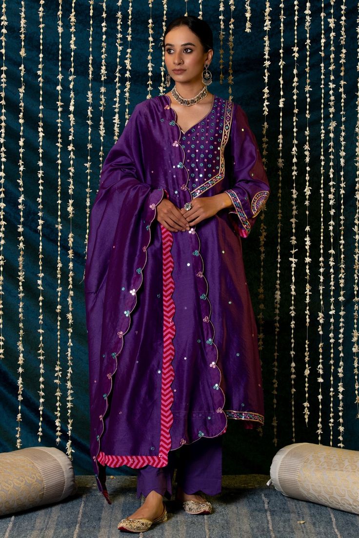 Purple kurta in chanderi silk base with thread and mirror hand embroidery and flared sleeves. Paired with farshi pants and embroidered dupatta.
Component: 3
Pattern: Embroidered
Type Of Work: Mirror, thread
Neckline: V neck
Sleeve Type: Flared
Fabric: Kurta and Dupatta: Chanderi silk, Farshi pants: Modal cotton
Color: Purple
Other Details: 
Flared sleeves detailed with motifs
Scalloped edges and detailed with mirror embroidery on dupatta
Occasion: Sangeet - Aza Fashions Lace Designs On Suits, Palazzo Dress, Kurta And Dupatta, Chanderi Silk Suits, Silk Kurta Set, Modern Royalty, Choli Dress, Zardozi Embroidery, Purple Mirror