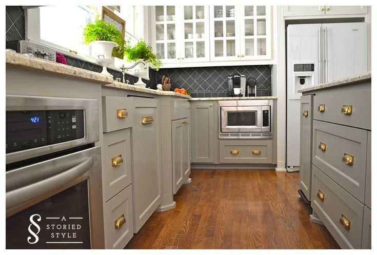 a kitchen with white cabinets and wood floors