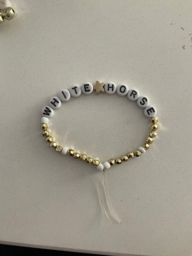 the white horse beaded bracelet and earring set is shown on top of a table