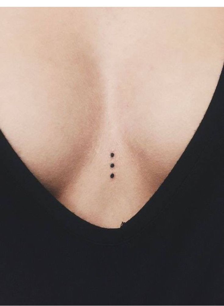 the back of a woman's chest with three dots on it and one dot in the middle