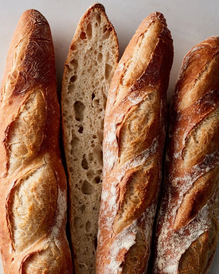 three loaves of bread sitting on top of a white countertop next to each other