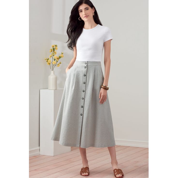 a woman in a white shirt and grey skirt