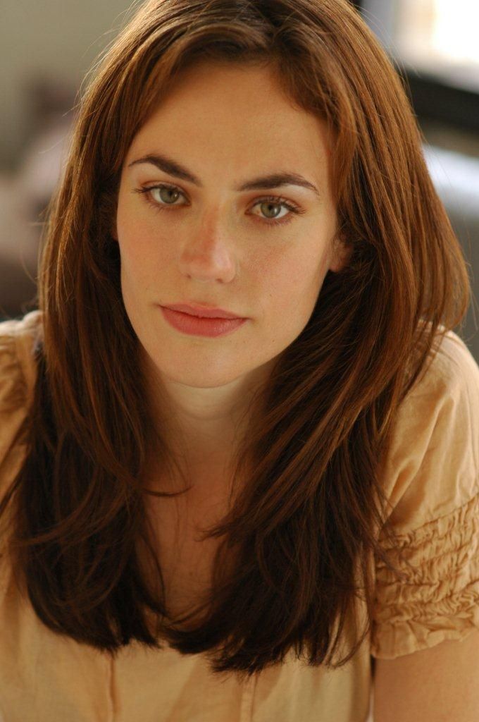 a woman with long brown hair sitting down