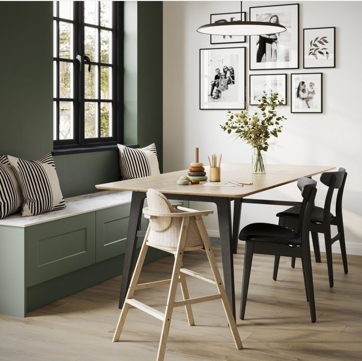 a dining room with green walls and pictures on the wall