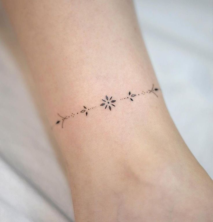 a small flower tattoo on the ankle