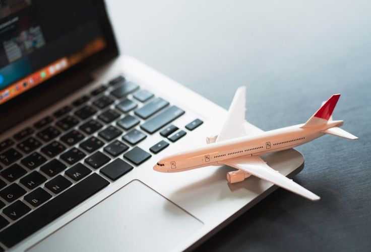 a model airplane sitting on top of a laptop computer