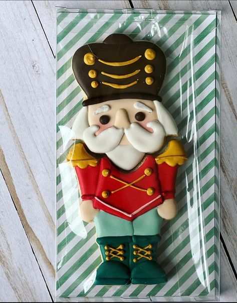 a cookie shaped like a nutcracker on top of a green and white striped paper