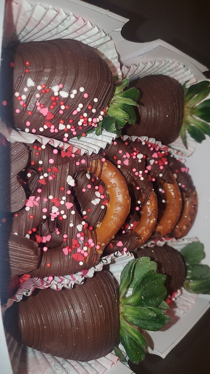 chocolate covered donuts with sprinkles and strawberries on a white plate