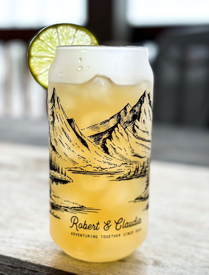 a tall glass filled with lemonade and lime sitting on top of a wooden table