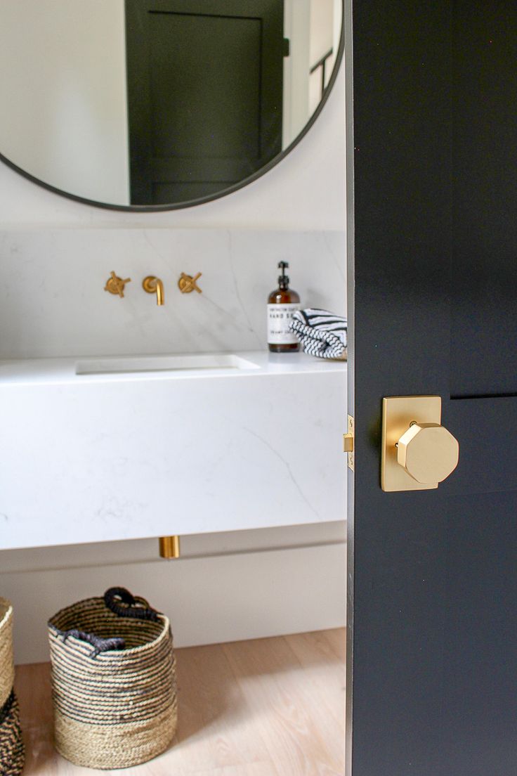 a bathroom with a sink, mirror and baskets on the floor