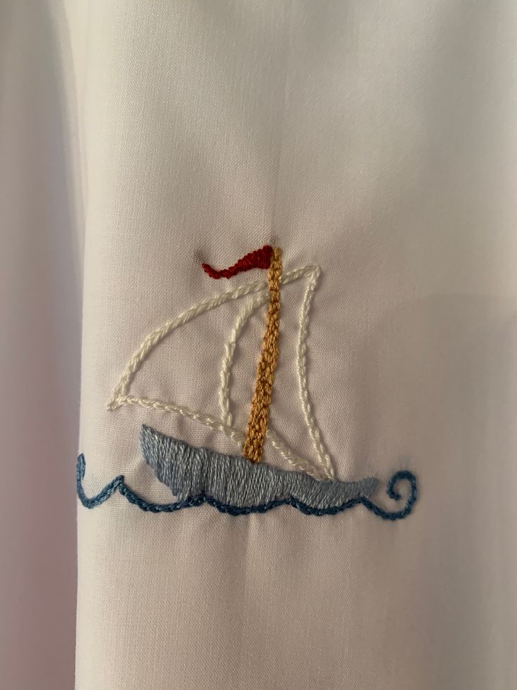 an embroidered sailboat on a white shirt