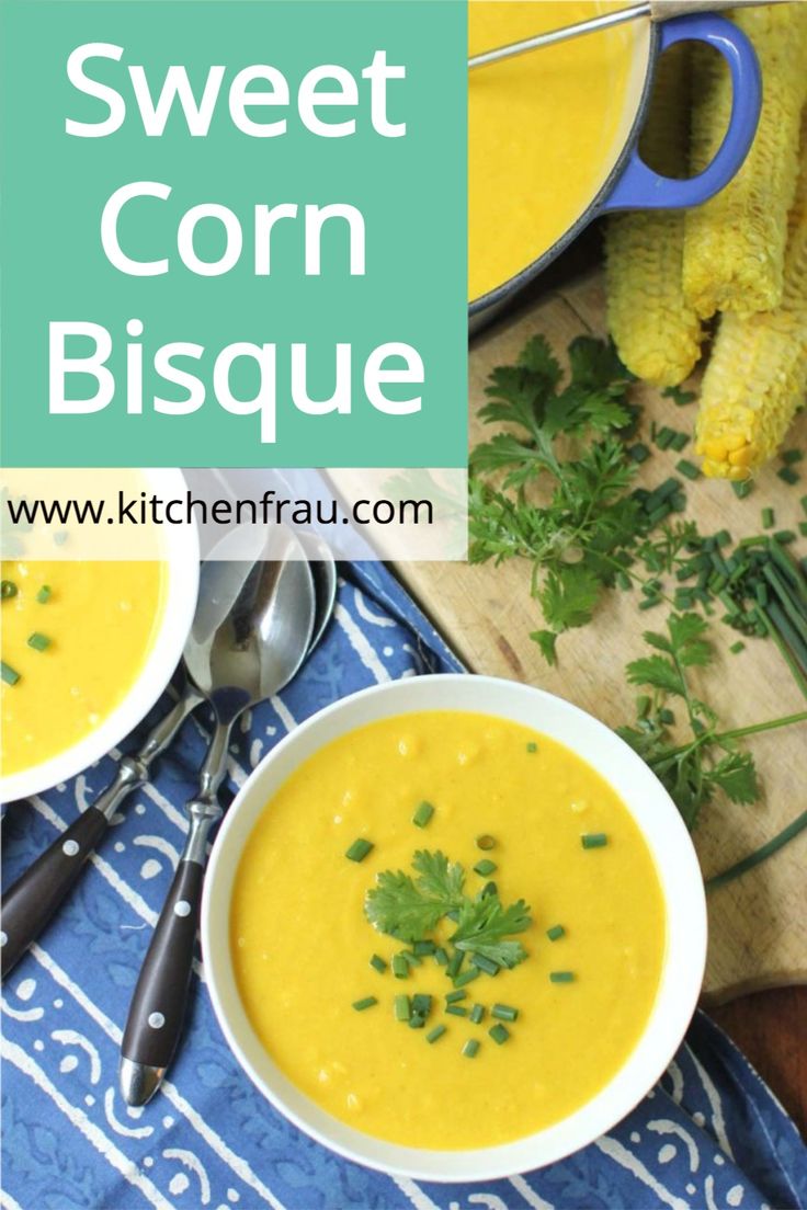 two bowls of corn bisque with garnish on the side and spoons next to it