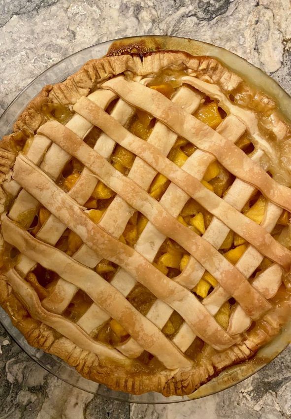 an apple pie sitting on top of a marble counter