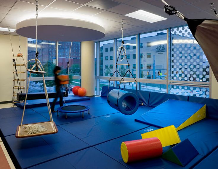 a child's play area in an office building with swings, slides and climbing equipment